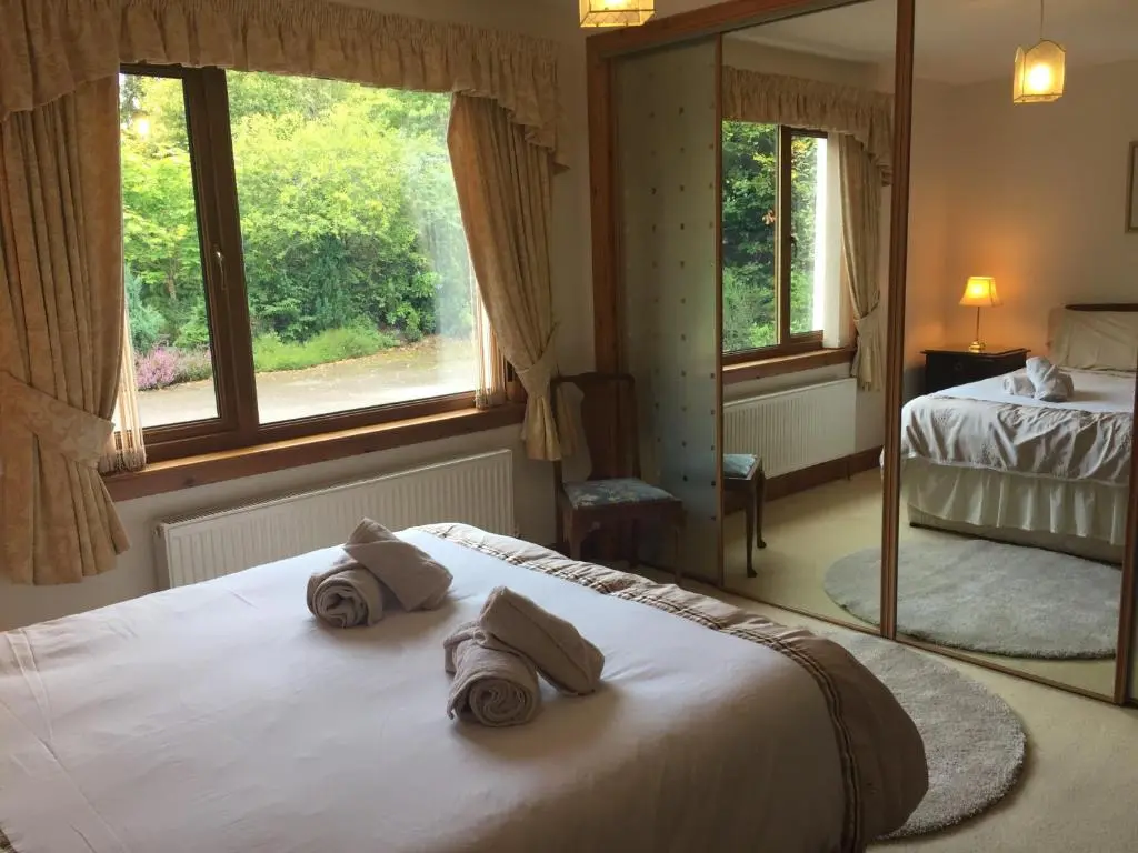 a bedroom with a bed and a large window at Rowans Inverness in Inverness