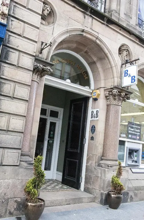 a building with a sign in front of a door at Bank Guest House in Wick