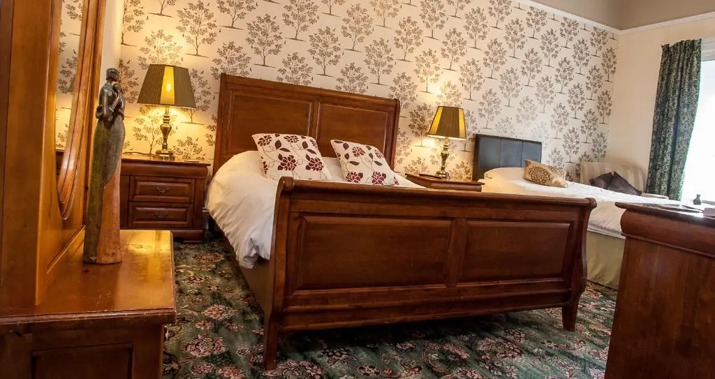 a bedroom with a large bed with white sheets at Bank Guest House in Wick
