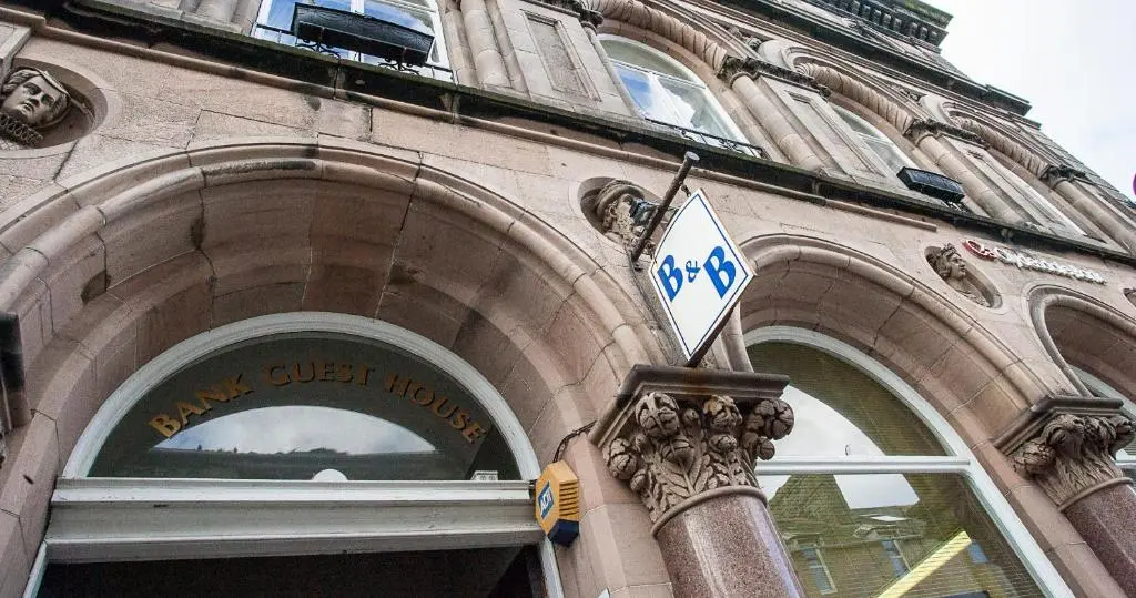 a building with a street sign in front of it at Bank Guest House in Wick