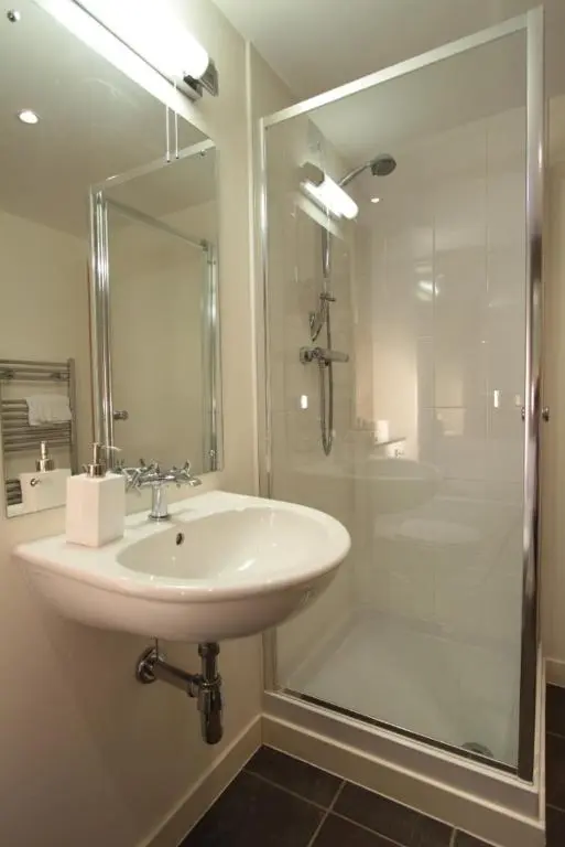 a white bathroom with a sink and a shower at Lovat Loch Ness Apartment with private roof terrace in Fort Augustus