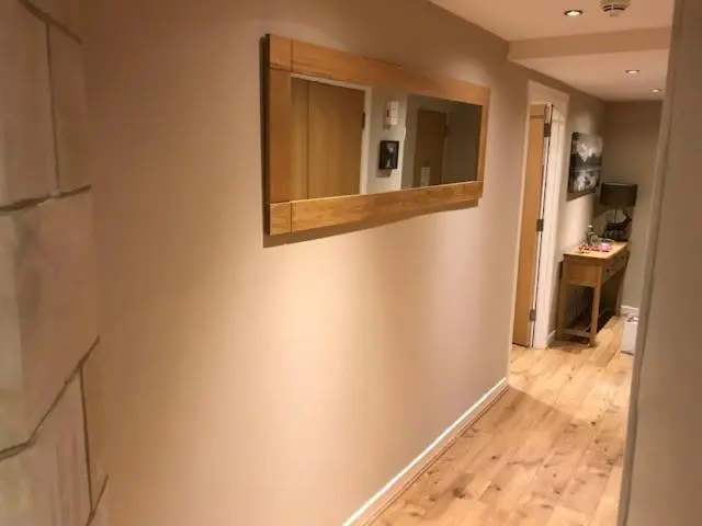 a hallway with a mirror on a wall at Lovat Loch Ness Apartment with private roof terrace in Fort Augustus