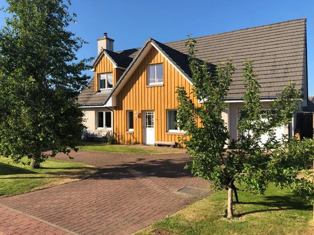 a yellow house with a gambrel roof at Hector's House in Aviemore
