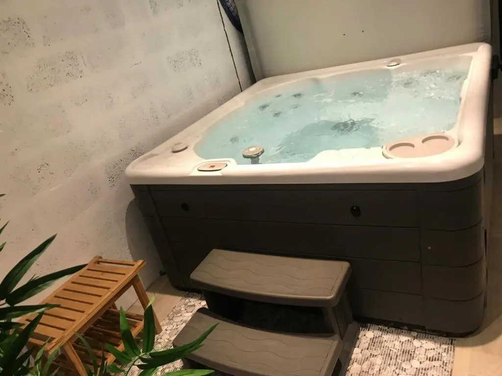 a bathroom with a bath tub with a bench in it at Hector's House in Aviemore