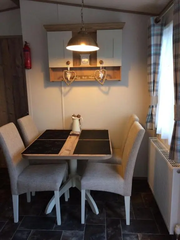 a dining room table and chairs in a room at Cragganmore Lodge in Aviemore