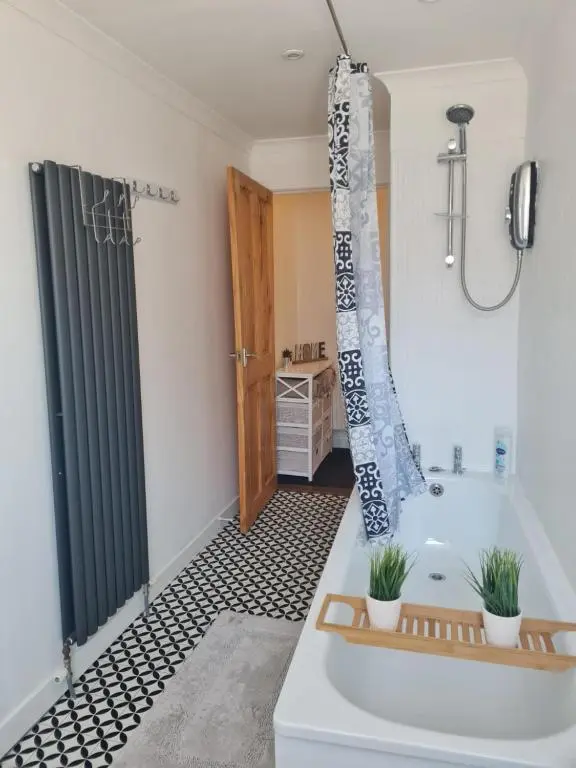a bathroom with a bath tub and a shower at Fisherman Cottage - ideal for Trades and couples part of Langley Serviced Apartments Has outside steps in Wick