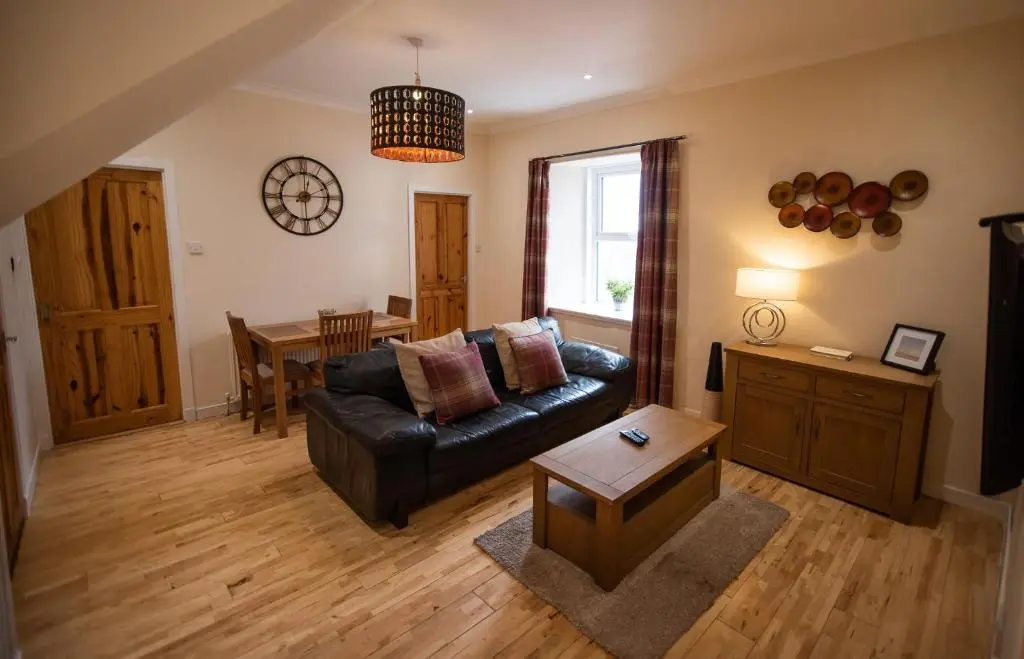 a living room with a couch and a table at Fisherman Cottage - ideal for Trades and couples part of Langley Serviced Apartments Has outside steps in Wick