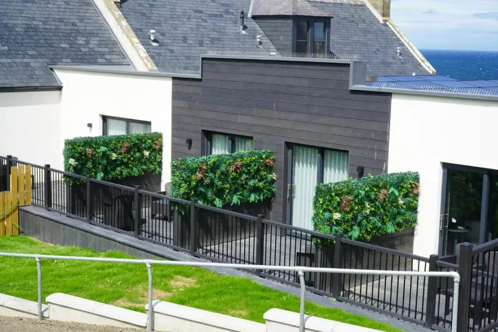 a house with flowers on the side of it at The Knowes Hotel & Restaurant in Macduff
