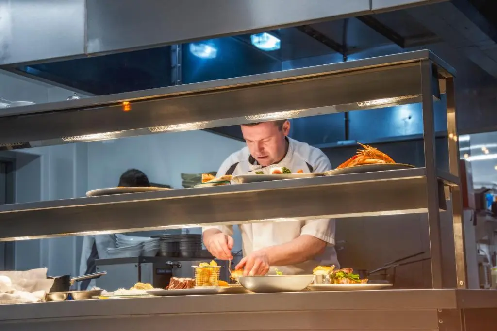 a chef preparing food in a restaurant kitchen at The Knowes Hotel & Restaurant in Macduff