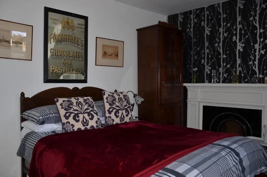 a bedroom with a bed with pillows and a fireplace at Averon House in Inverness
