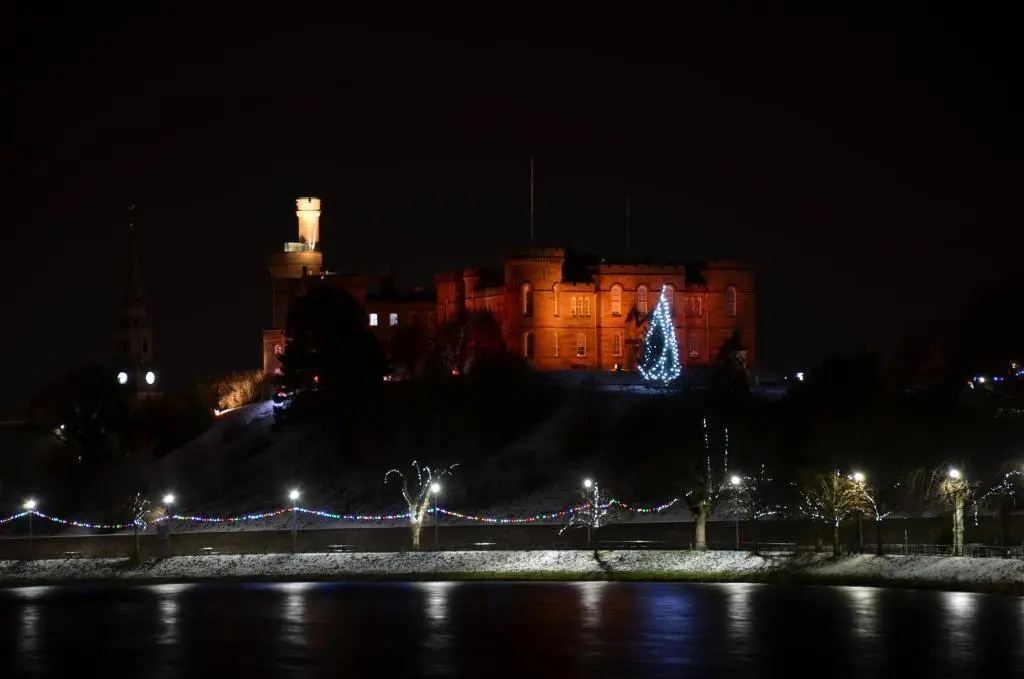 a castle at night with a christmas tree in front at Averon House in Inverness