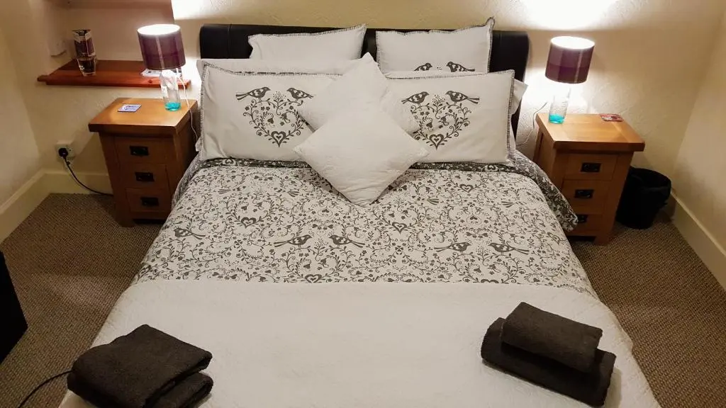 a bedroom with a large bed with pillows at Doric House in Inverness