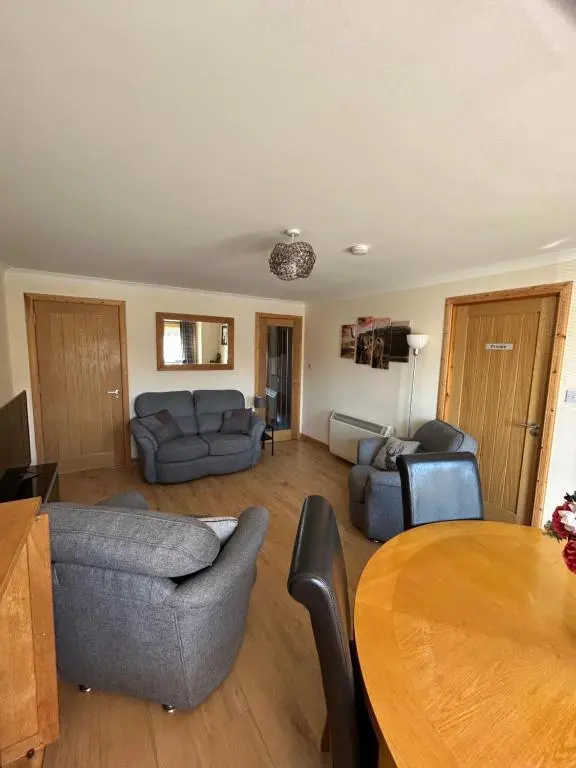 a living room with a couch and a table at No 52 - Apartment with Lounge and Dining Area - No kitchen in Ullapool