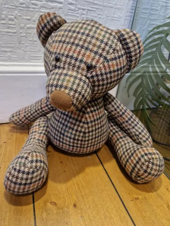 a stuffed teddy bear sitting on the floor at Eagle View Guest House in Newtonmore