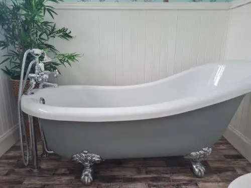 a white bath tub in a bathroom with a plant at Eagle View Guest House in Newtonmore