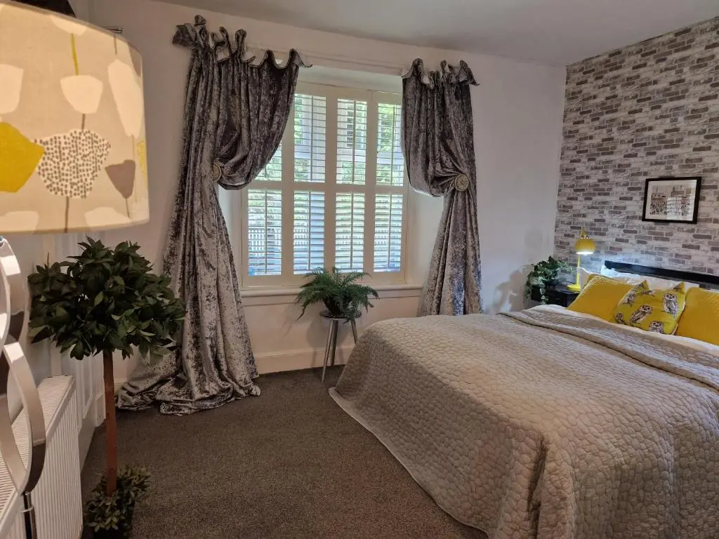 a bedroom with a large bed with yellow pillows at Eagle View Guest House in Newtonmore
