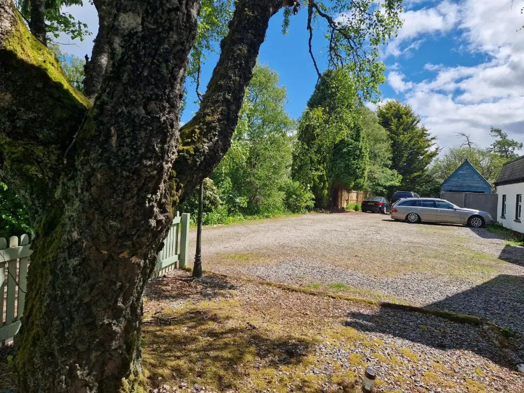 a driveway with a car parked next to a fence at Eagle View Guest House in Newtonmore