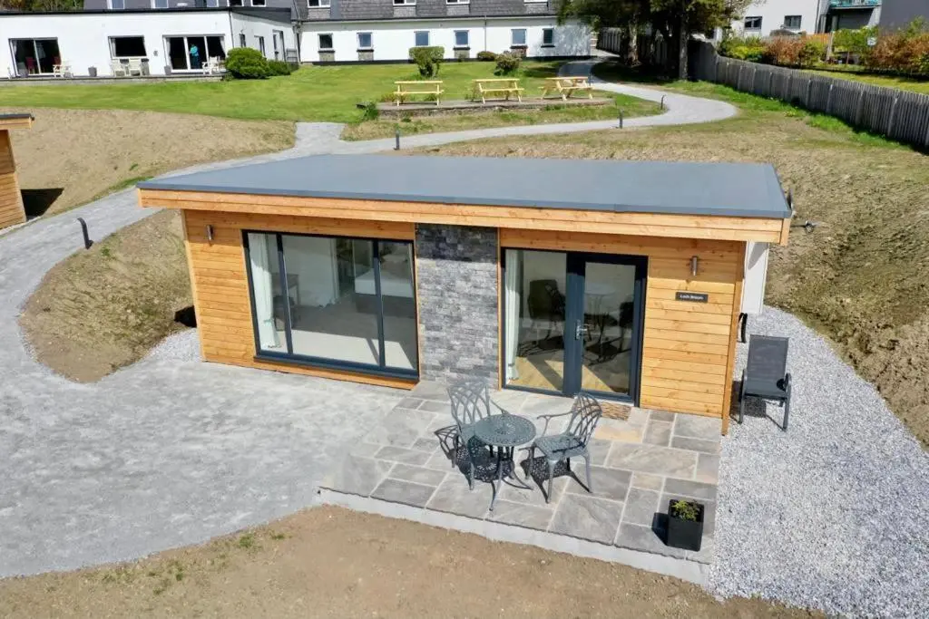 a tiny house with a patio and a table at Harbour House in Ullapool