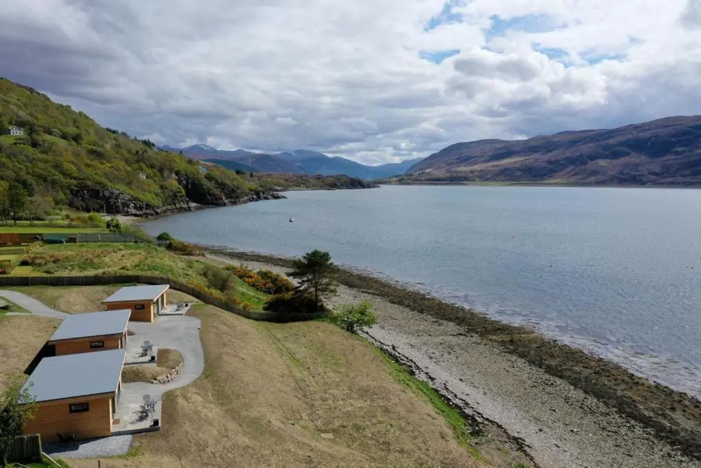 arial view of a lake with houses and mountains at Harbour House in Ullapool