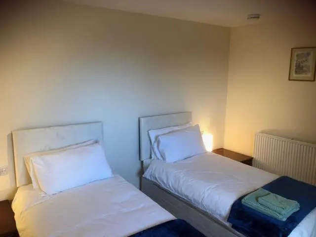 two beds sitting next to each other in a room at Broadsea in Inverurie