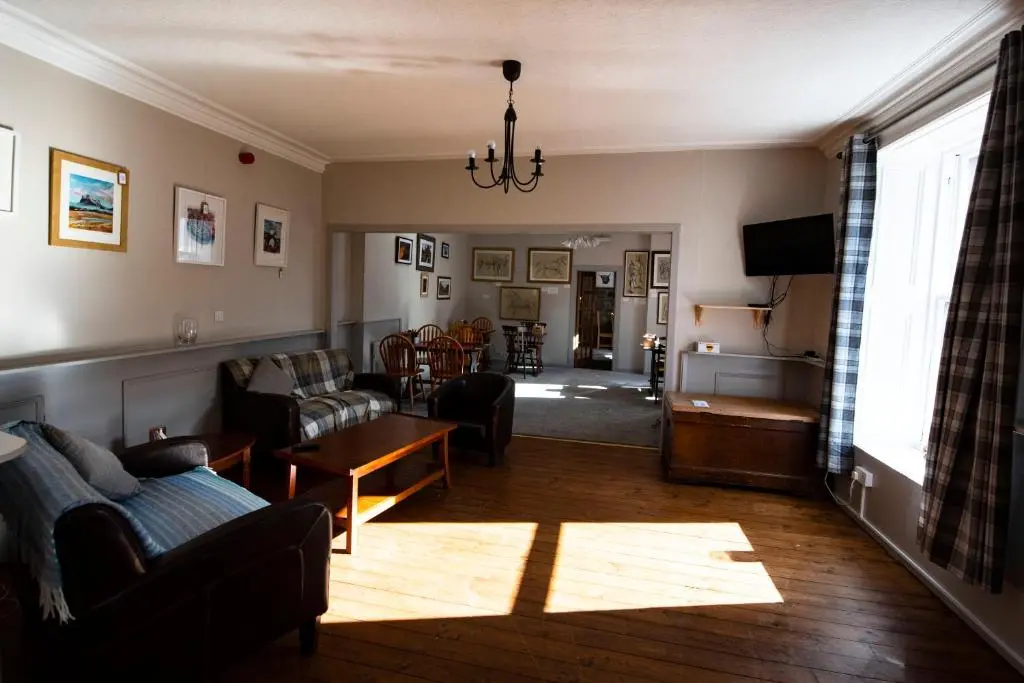 a living room with a couch and a table at The Kirkmichael Hotel in Kirkmichael