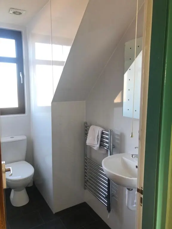 a white bathroom with a toilet and a sink at Elgin Guest House in Elgin