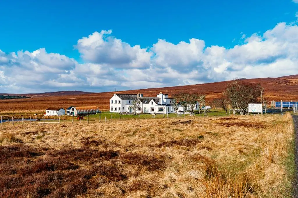 a large white house in the middle of a field at Garvault House in Kinbrace