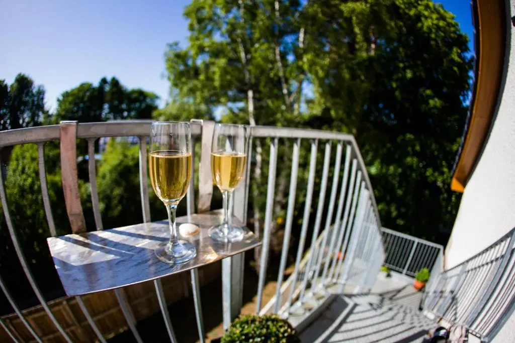 two glasses of wine sitting on a table on a balcony at Mulberry in Nairn