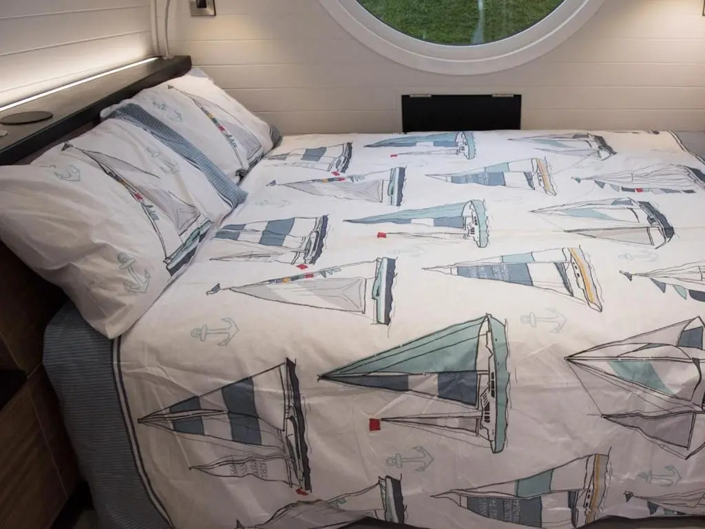 a bed in a small room with airplanes on it at Door to the Shore - Seafront Cottages in Sandhaven