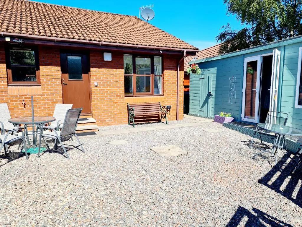 a patio with a table and chairs in front of a house at Aviemore Stay & Explore in Aviemore