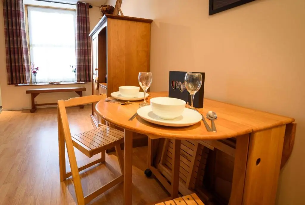 a wooden table with two plates and glasses on it at The Old Chemist in Cullen