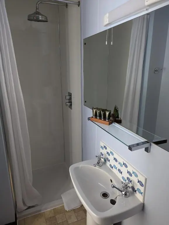 a white bathroom with a sink and a shower at Furain in Peterculter
