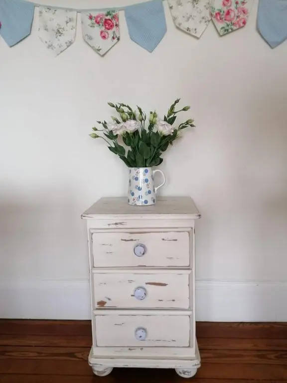 a vase of flowers sitting on top of a dresser at Furain in Peterculter