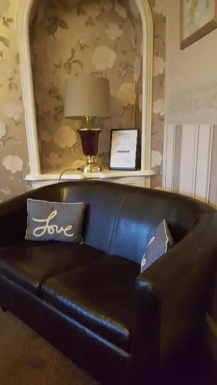 a black leather couch in a living room with a mirror at Ivanhoe Guest House in Inverness