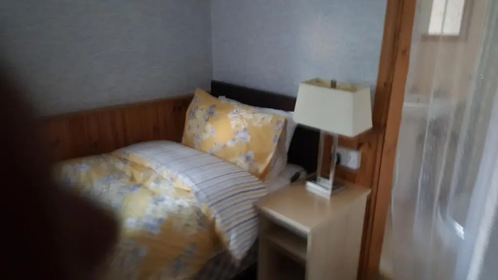 a bedroom with a bed and a lamp on a night stand at Ivanhoe Guest House in Inverness