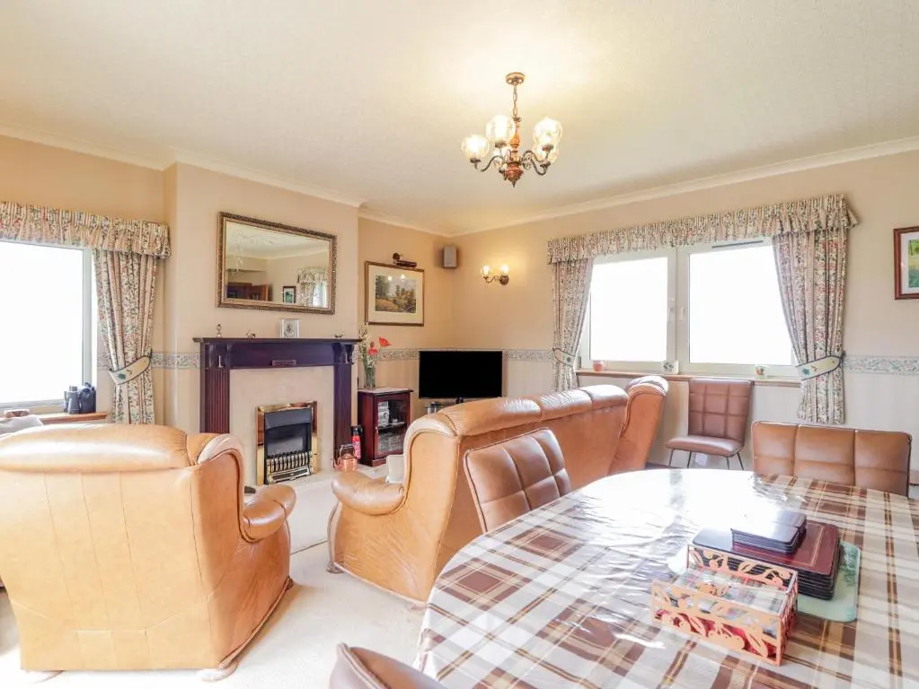 a living room with leather furniture and a table at Braehead Croft in Portessie
