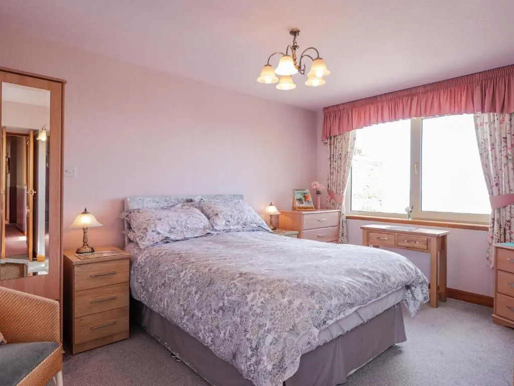 a bedroom with a bed and a window at Braehead Croft in Portessie