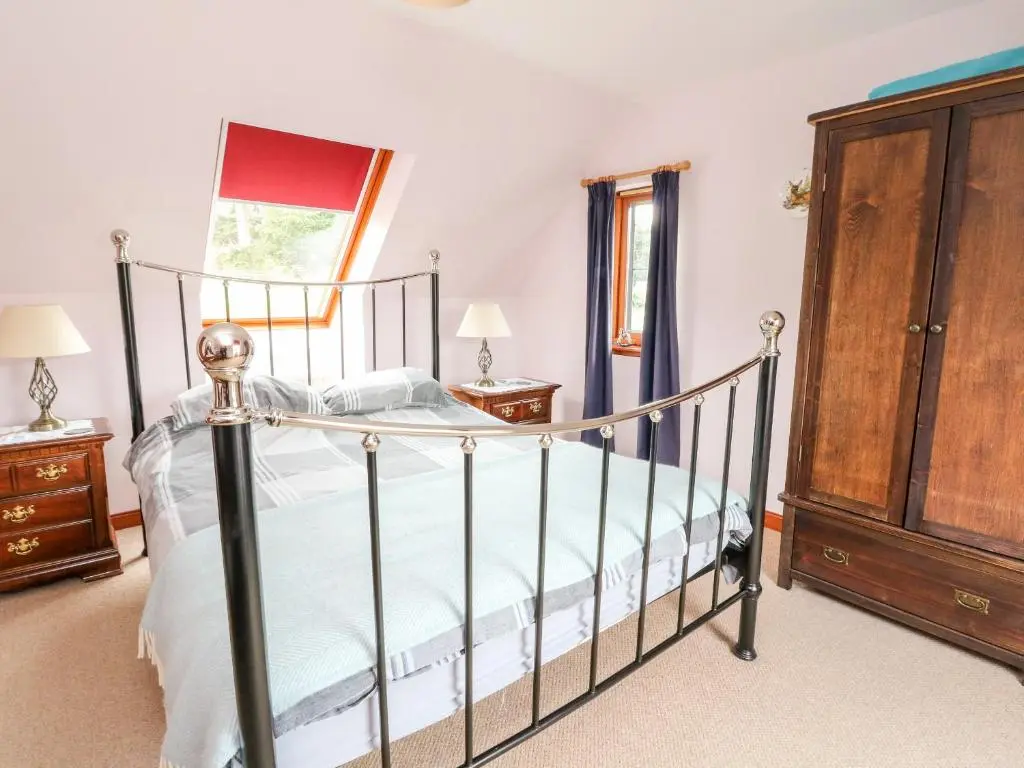 a bedroom with a bed and a wooden cabinet at Creag-na-Sanais in Laggan