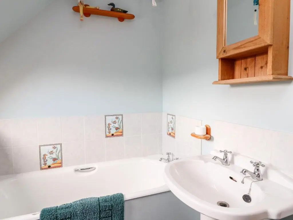 a white bathroom with a sink and a bath tub at Creag-na-Sanais in Laggan