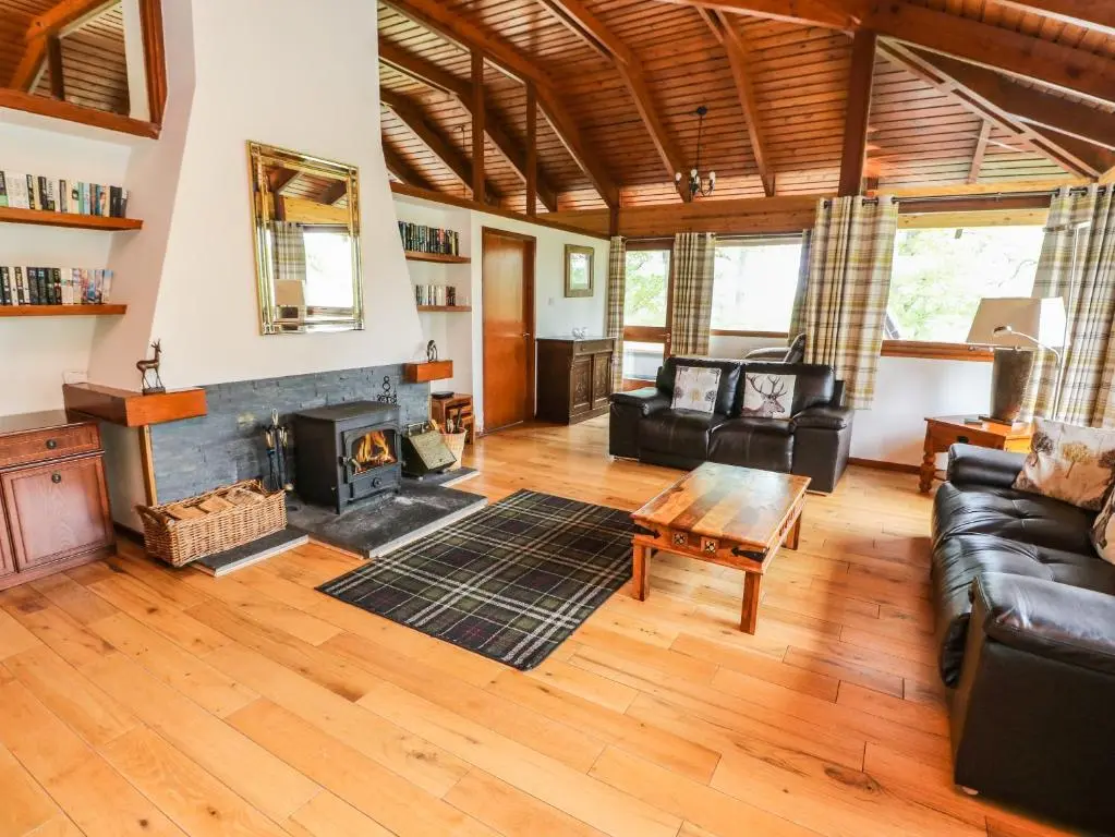 a living room with a couch and a fireplace at Katchana in Insh
