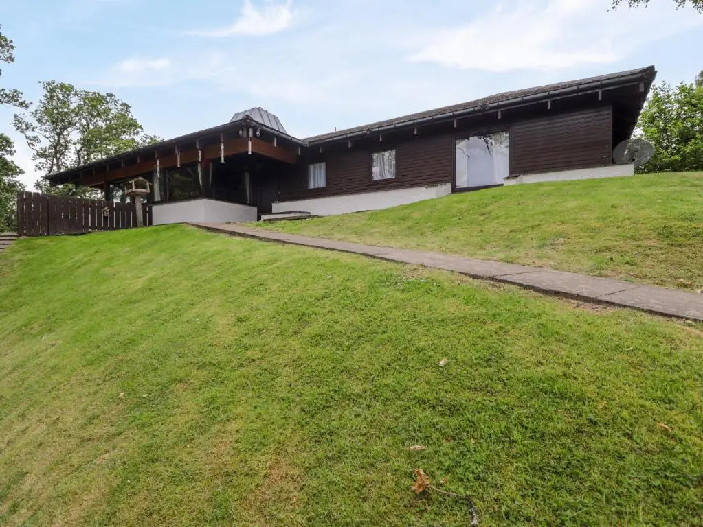 a house with a large yard in front of it at Katchana in Insh
