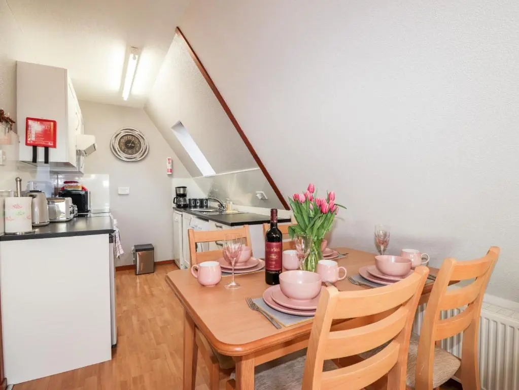 a kitchen and dining room with a table and chairs at Larchfield Chalet 2 in Auchterneed