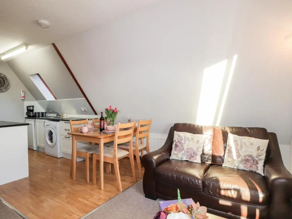 a living room with a couch and a table at Larchfield Chalet 2 in Auchterneed