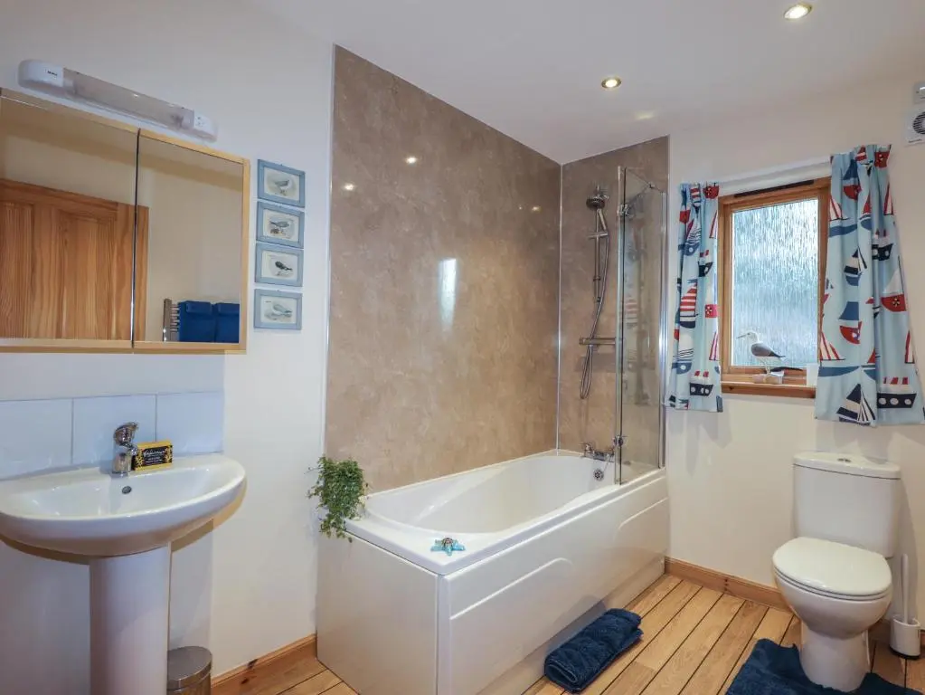a bathroom with a tub and a sink and a toilet at Bruach Gorm Cottage in Grantown on Spey