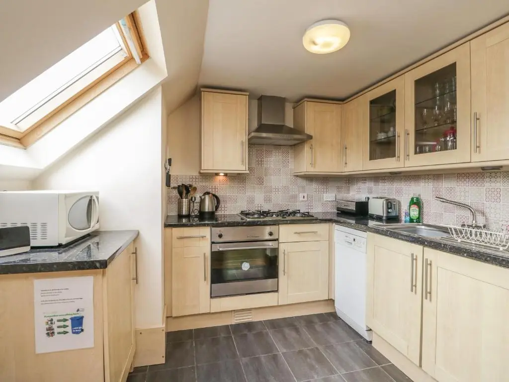 a kitchen with wooden cabinets and a sink at 10 Monarch Country Apartments in Newtonmore