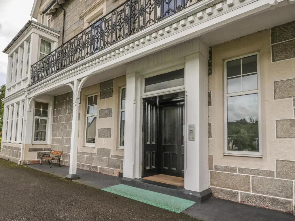 a building with a balcony on top of it at 10 Monarch Country Apartments in Newtonmore