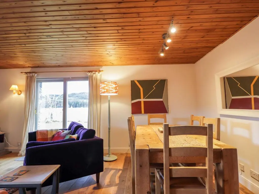 a living room with a table and a dining room at Inshcraig in Kincraig