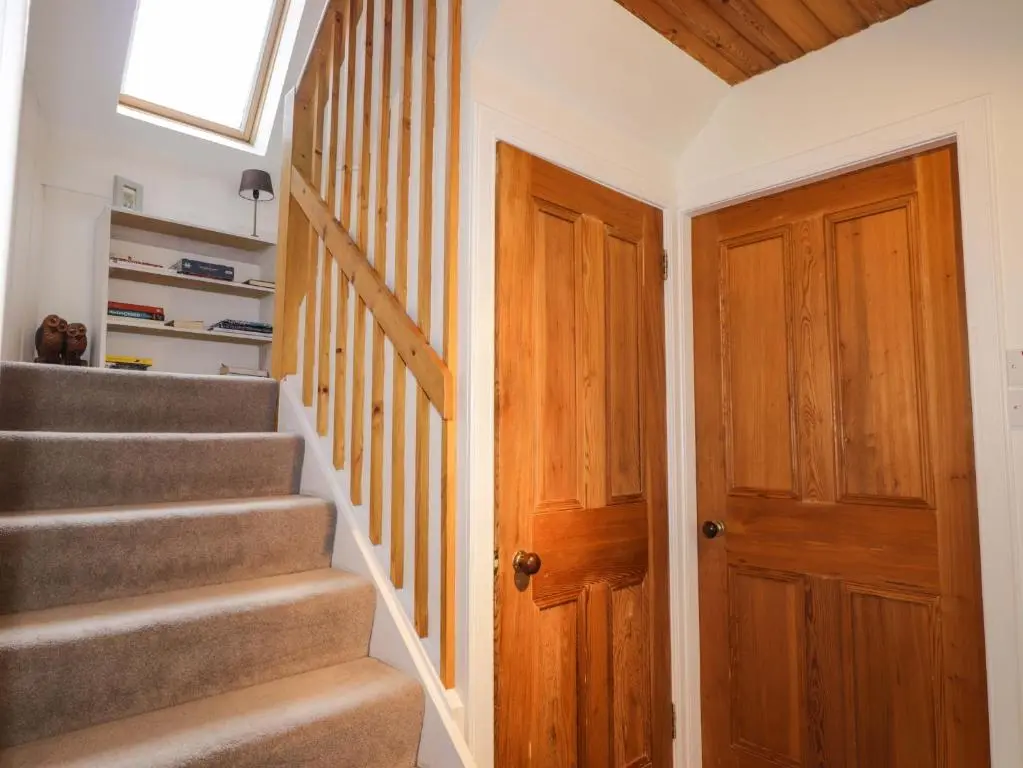 a stairway with a wooden door and stairs with a window at Inshcraig in Kincraig
