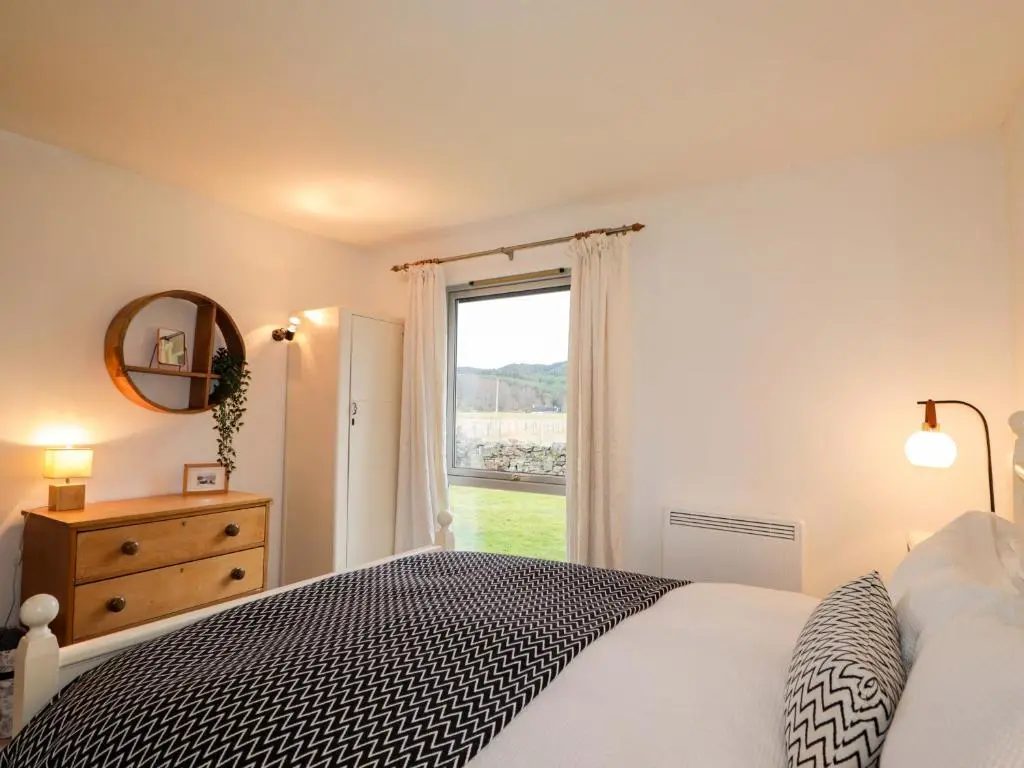 a bedroom with a bed and a large window at Inshcraig in Kincraig