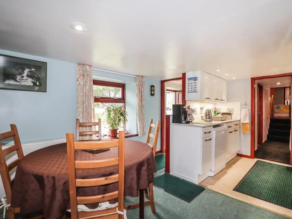 a kitchen and a dining room with a table and chairs at Blairgorm Croft in Nethy Bridge